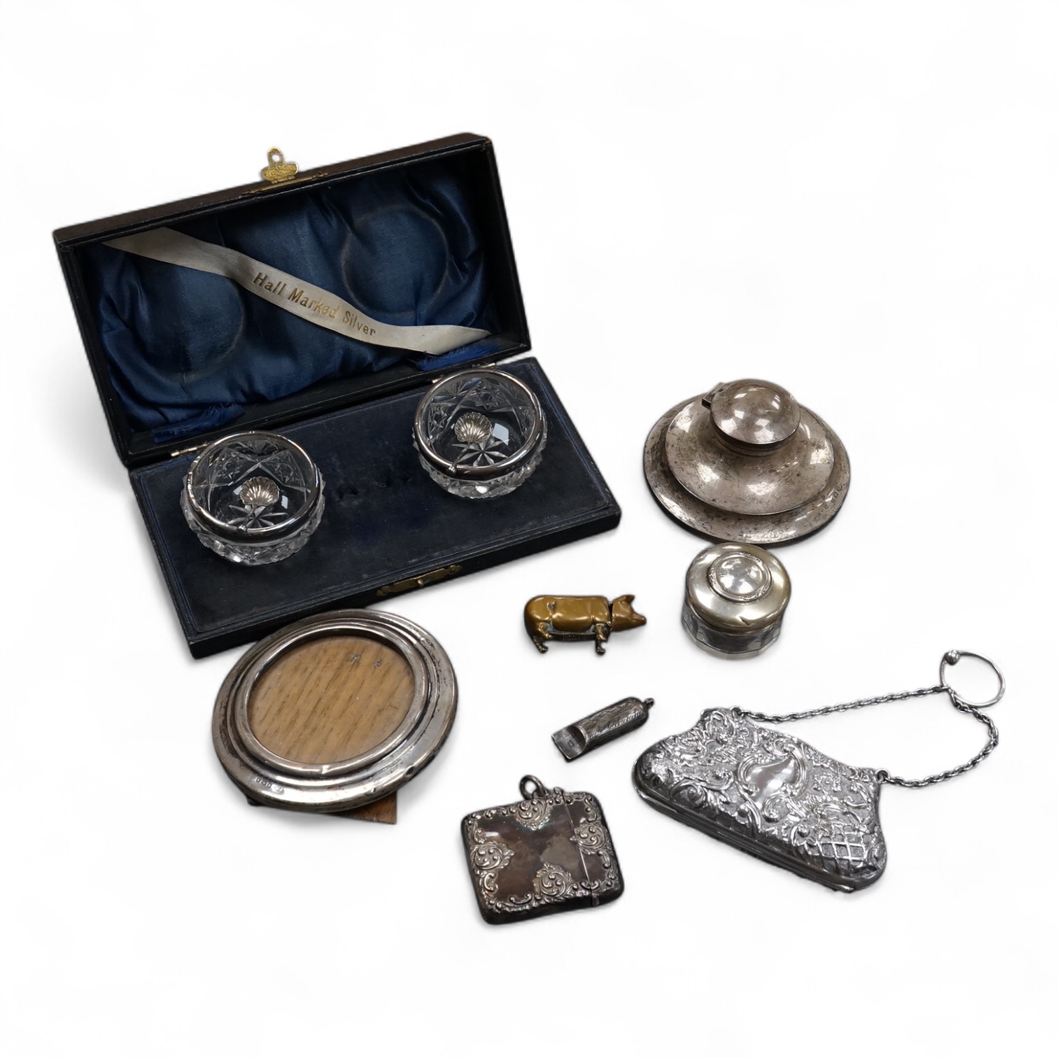 An Edwardian repousse silver purse, with suspension chain, Henry Matthews, Birmingham, 1902, 90mm, together with a silver vesta case, a silver mounted capstan inkwell, a silver mounted toilet jar, a George V silver mount